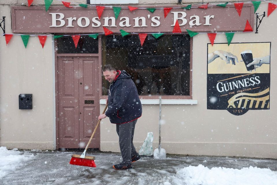 Pub owner Micheal Brosnan clears a path outside his bar in in Cashel, Co Tipperary. Photo: Reuters